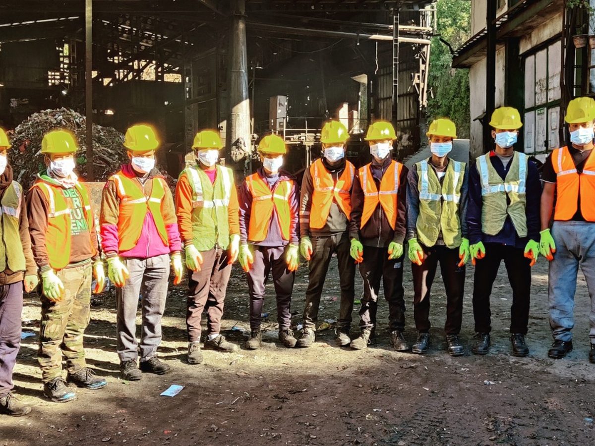 Site team lined up in PPE — helmets, vests and gloves